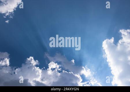 A dramatic sky of endless blue and white clouds illuminated by bright sunlight, creating a beautiful atmosphere amongst the natural environment. Stock Photo