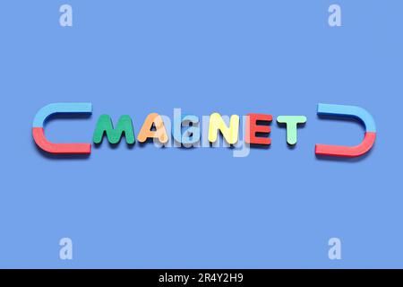 Horseshoe shaped magnets with word MAGNET on blue background Stock Photo