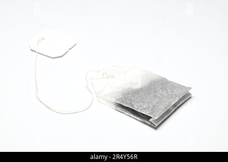 dry tea bag on a white background. One rectangular tea bag closeup. Herbal and black tea bags. Stock Photo