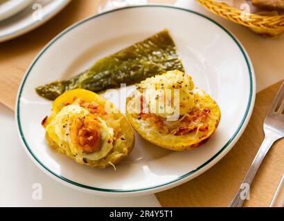 Twice baked potatoes stuffed with meat, jam, cheese and egg Stock Photo