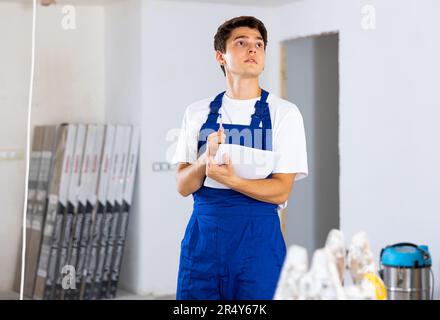 Young builder making checklist while planning indoor building overhaul Stock Photo