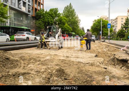 Tbilisi Georgia road works. Workers, bulldozer machine repairing street construction works. Stock Photo