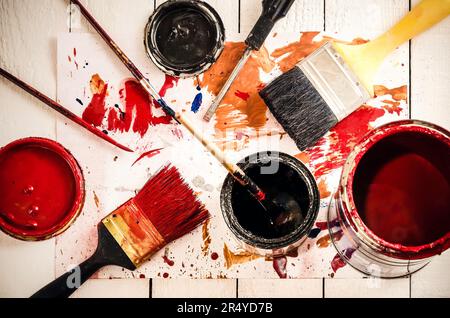Brushes and colorful paints. Brushes and spilled paint on the floor. Stock Photo
