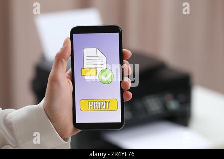 Man using printer management application on mobile phone indoors, closeup and space for text Stock Photo