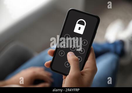 Privacy protection. Man entering pin code on smartphone, closeup. Lock and numpad on screen Stock Photo