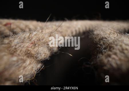 Textured organic twisted ropes lie on black table in studio Stock Photo