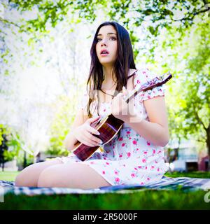 Young Woman Singing and Composing a Song in a Park | Summer Dress Stock Photo