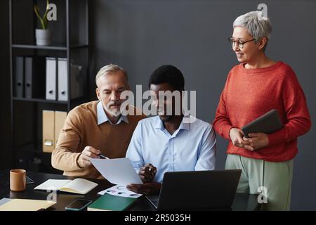 Diverse group of business people with senior representatives working on project together at workplace in office Stock Photo