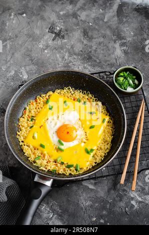 Kujirai Ramen, Shin Ramyeon or Ramyun with Egg, Melted Cheese and Scallion, Instant Noodles on Dark Background Stock Photo