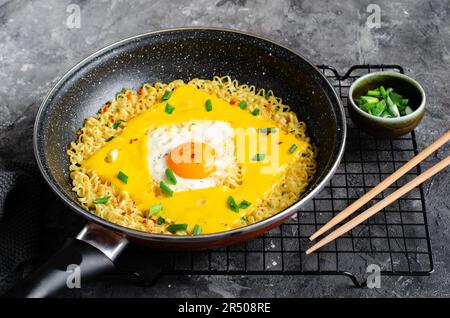 Kujirai Ramen, Shin Ramyeon or Ramyun with Egg, Melted Cheese and Scallion, Instant Noodles on Dark Background Stock Photo