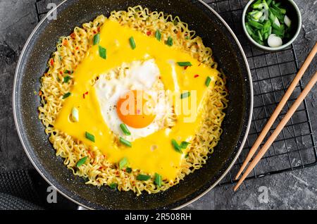 Kujirai Ramen, Shin Ramyeon or Ramyun with Egg, Melted Cheese and Scallion, Instant Noodles on Dark Background Stock Photo