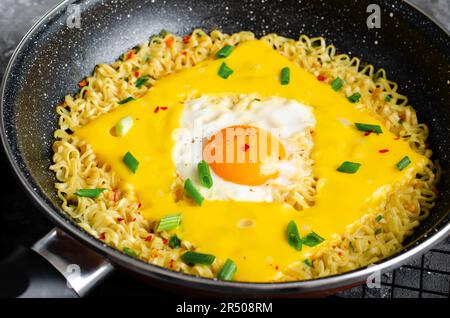 Kujirai Ramen, Shin Ramyeon or Ramyun with Egg, Melted Cheese and Scallion, Instant Noodles on Dark Background Stock Photo