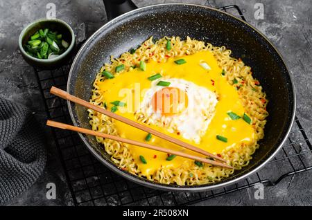 Kujirai Ramen, Shin Ramyeon or Ramyun with Egg, Melted Cheese and Scallion, Instant Noodles on Dark Background Stock Photo