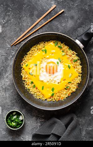 Kujirai Ramen, Shin Ramyeon or Ramyun with Egg, Melted Cheese and Scallion, Instant Noodles on Dark Background Stock Photo