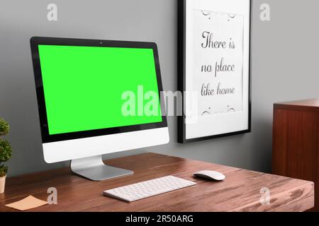 Computer display with chroma key on desk in room. Comfortable workplace Stock Photo