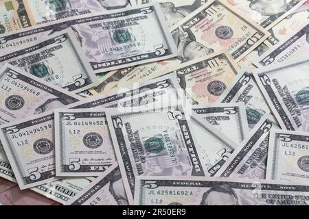 A scattered pile of United States Paper five and ten dollar notes Stock Photo