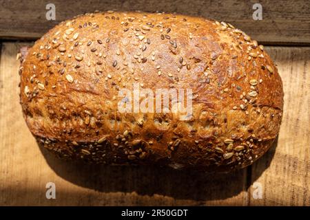 Crusty homemade organic wholegrain bread on a rustic wooden table Stock Photo
