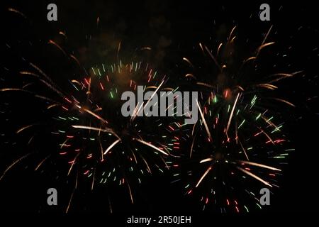 Beautiful fireworks lighting up night sky outdoors Stock Photo