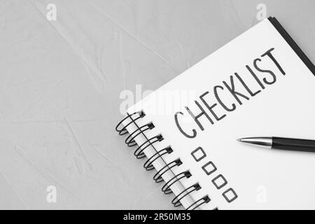 Notebook with inscription Checklist on light grey table, top view. Space for text Stock Photo