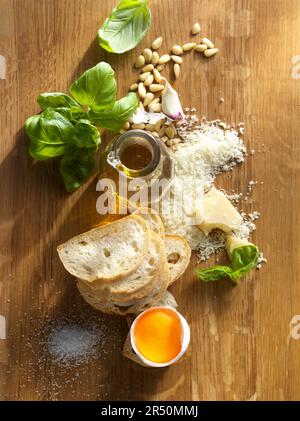 Ingredients for pesto, bread slices, and a broken egg Stock Photo