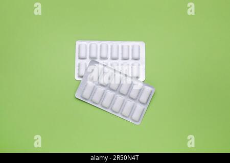 Blisters with chewing gums on pale green background, flat lay Stock Photo