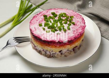 Herring under fur coat salad served on white table. Traditional Russian dish Stock Photo