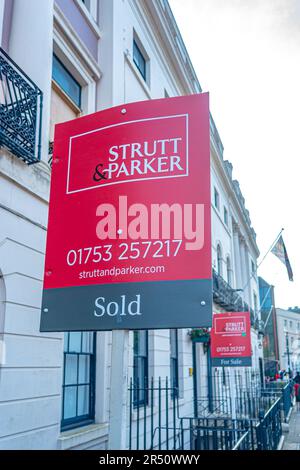 Estate Agents signs outside properties in Windsor, UK, one of which is sold and the other for sale. Stock Photo