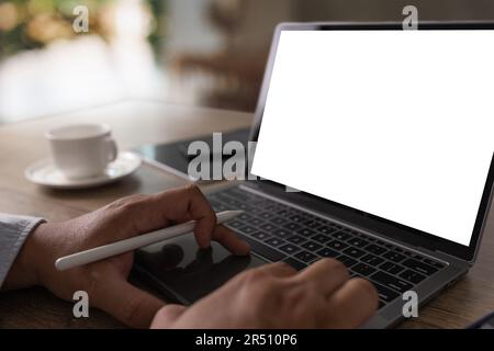Laptop with blank screen on table interior, man at his workplace using technology Stock Photo