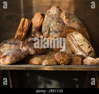 Various rustic breads on a wooden table Stock Photo