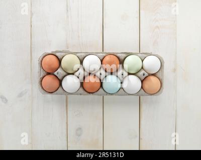 Various coloured eggs in an egg box Stock Photo