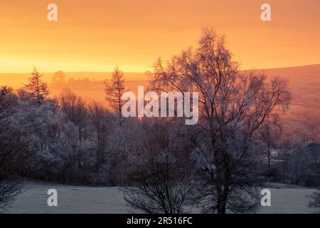 North York Moors national park. Daybreak view over Commondale village as the winter sun rises over the surrounding hills on a frosty morning. Stock Photo