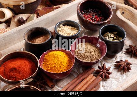 Various spices in small bowls on a wooden tray Stock Photo