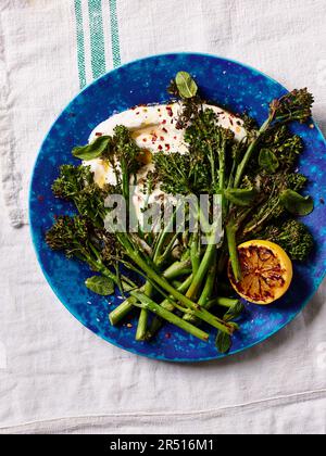 Charred broccoli and lemon on mint yogurt Stock Photo