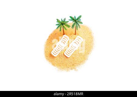 Top view of a miniature toy composition with sunbeds and palm tree figurines placed on a small pile of sand isolated on white background. Creative Tro Stock Photo