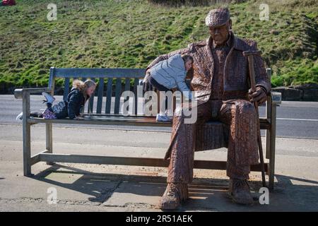 Children climbing on the sculpture 'Freddie Gilroy and the Belsen Stragglers' by Ray Lonsdale, North Bay, Scarborough, Yorkshire Stock Photo