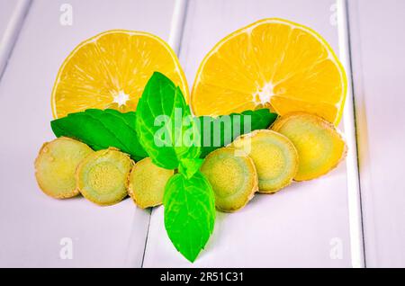 Lemons, ginger and mint leaves.   Lemon, ginger and mint leaves on a wooden white table. Stock Photo