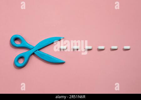 Plasticine scissors with cut lines on pink background. Concept of craft works, design or fashion. Stock Photo