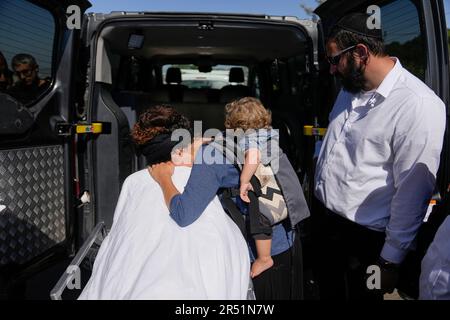 Tal Tamari carries her son as she mourns over the body of her husband ...