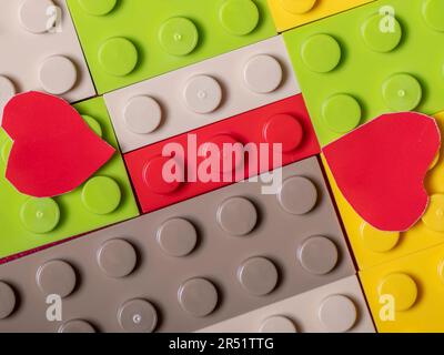 Pattern of colorful plastic bricks with two red hearts above Stock Photo