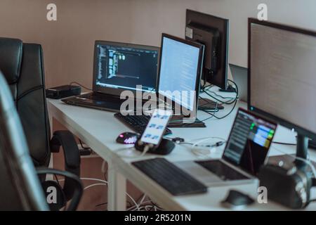Computer screens running programming code in empty software developing agency office and computers parsing data algorithms in background. Neural Stock Photo