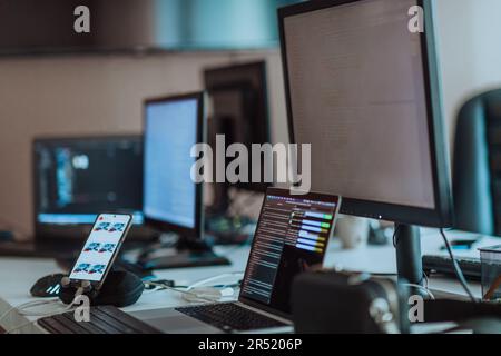 Computer screens running programming code in empty software developing agency office and computers parsing data algorithms in background. Neural Stock Photo