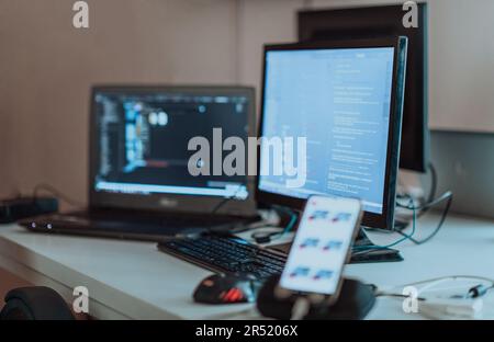 Computer screens running programming code in empty software developing agency office and computers parsing data algorithms in background. Neural Stock Photo