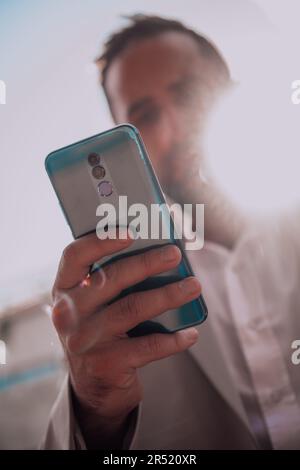 A businessman using his smartphone outdoors, showcasing the seamless integration of technology and mobility in modern professional life. Stock Photo