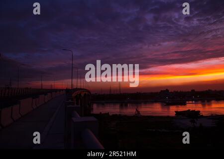 Sunset over the river in the city. The bridge crosses the river Stock Photo