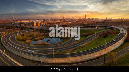Secaucus Junction Station Sunset - Aerial  panoramic to the New Jersey Turnpike very long ramp, the illuminated train station along  with a view to th Stock Photo