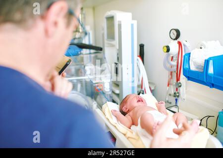 https://l450v.alamy.com/450v/2r527ge/crying-newborn-baby-on-weight-scale-in-hospital-first-days-of-life-2r527ge.jpg