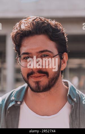 A portrait of a modern man, exuding confidence and style, against an outdoor backdrop, showcasing his charisma and fashionable demeanor. Stock Photo