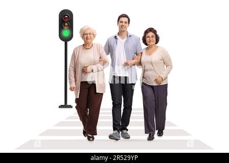 Full length portrait of a young man walking with two mature women at a pedestrian crossing isolated on white background Stock Photo