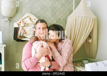 Happy family with baby, first time parents holding newborn daughter Stock Photo