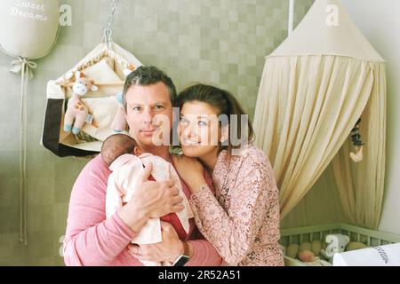 Happy family with baby, first time parents holding newborn daughter Stock Photo